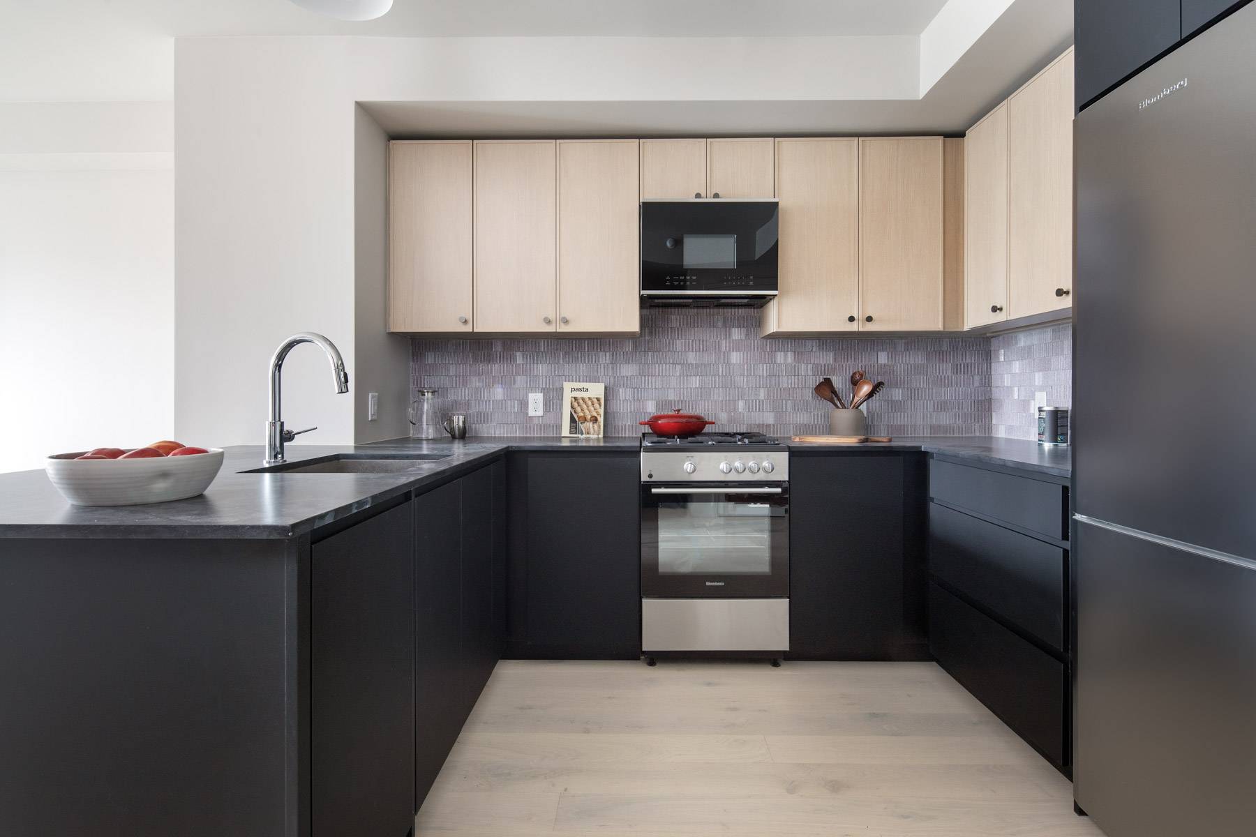 Chef Inspired Kitchen with dark cabinets on bottom and light cabinets on top with stainless steel oven and fridge