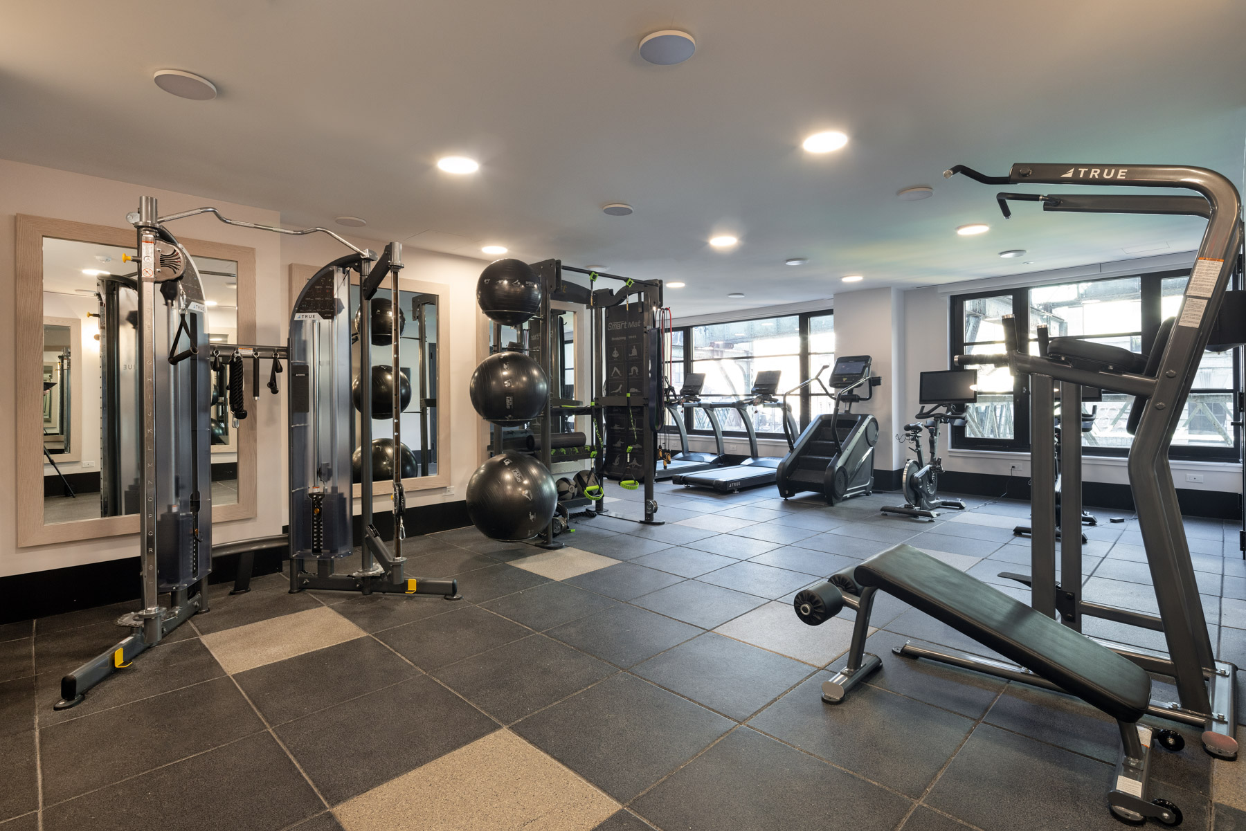 Fitness Center with large windows, mirrors, various weight and cardio equipment